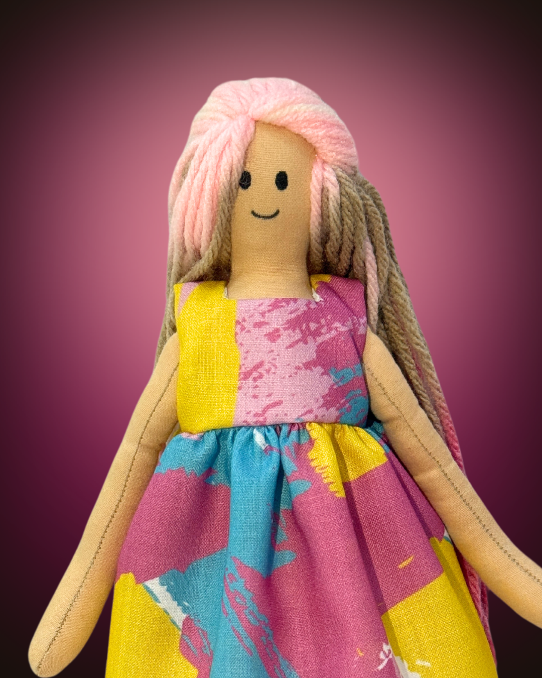 Plastic-free rag doll with soft pink hair and a colorful splash-print dress, encouraging creativity and safe play