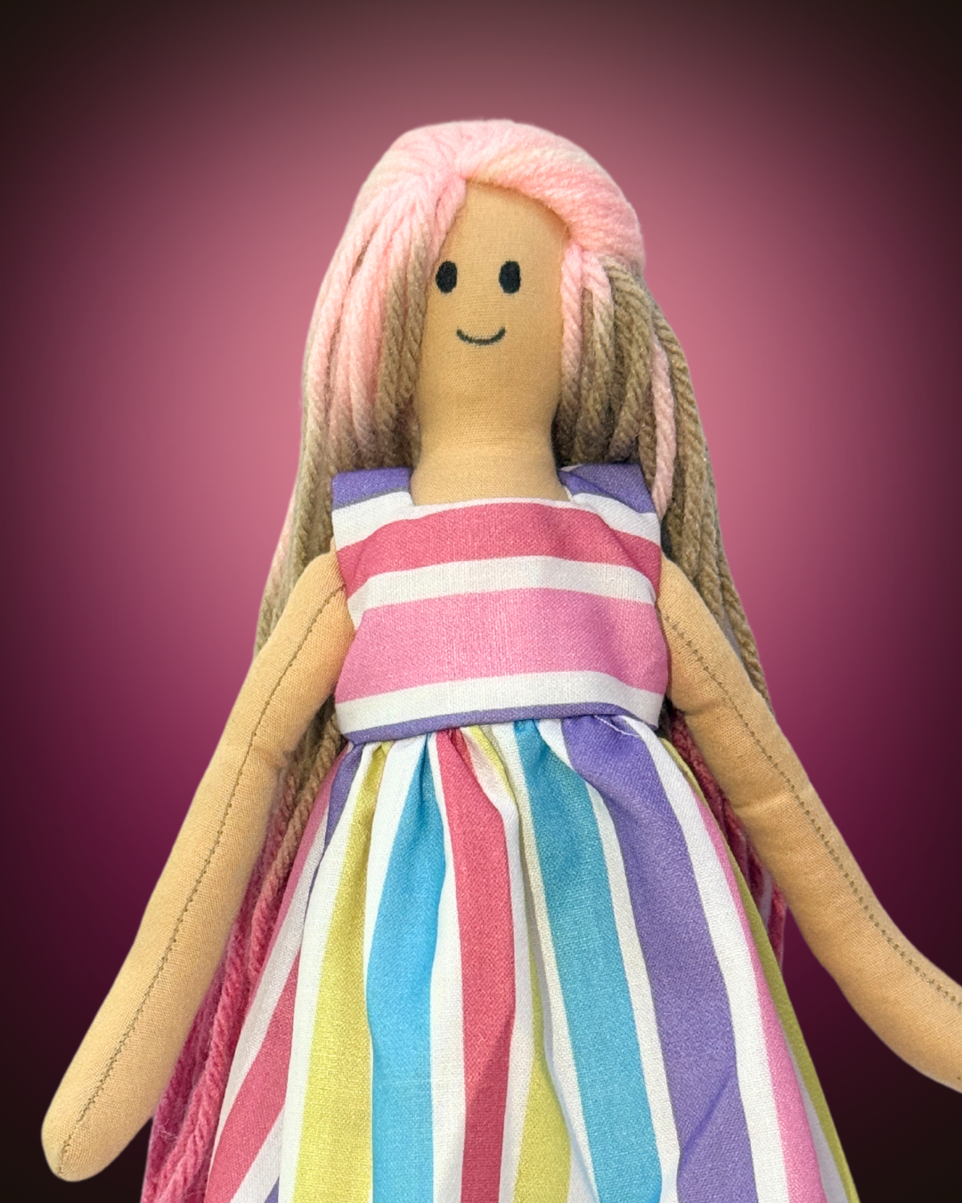 Eco-friendly doll with pink hair and a pastel rainbow-striped dress, ideal for toddlers and young children