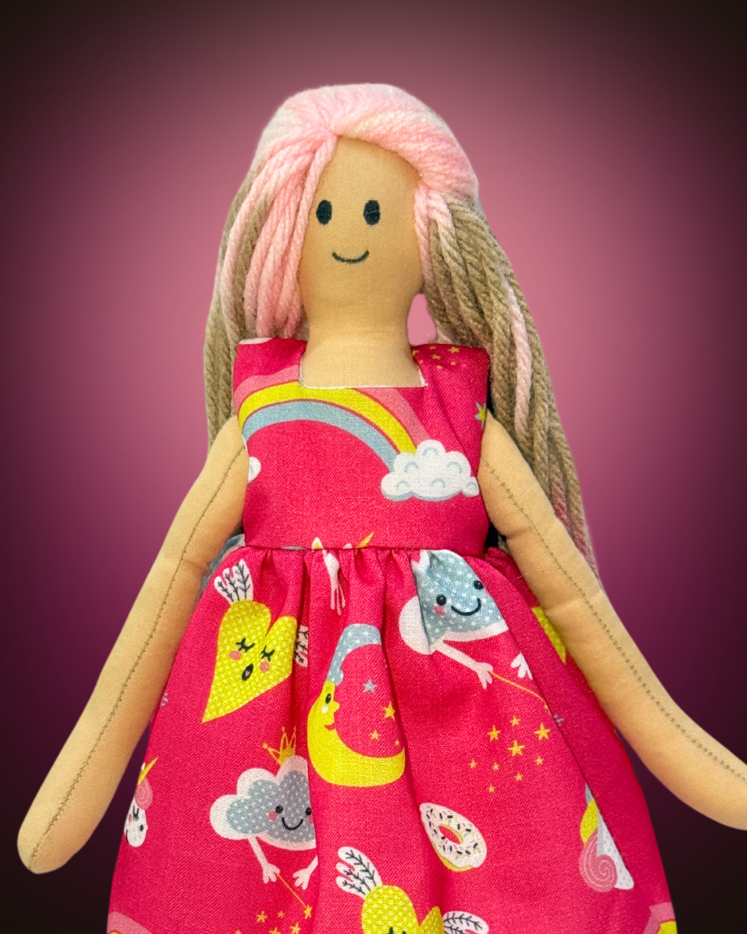 Sustainable soft doll (UNINA HONEY BLUSHIE) dressed in a playful pink rainbow outfit, ideal for toddlers.