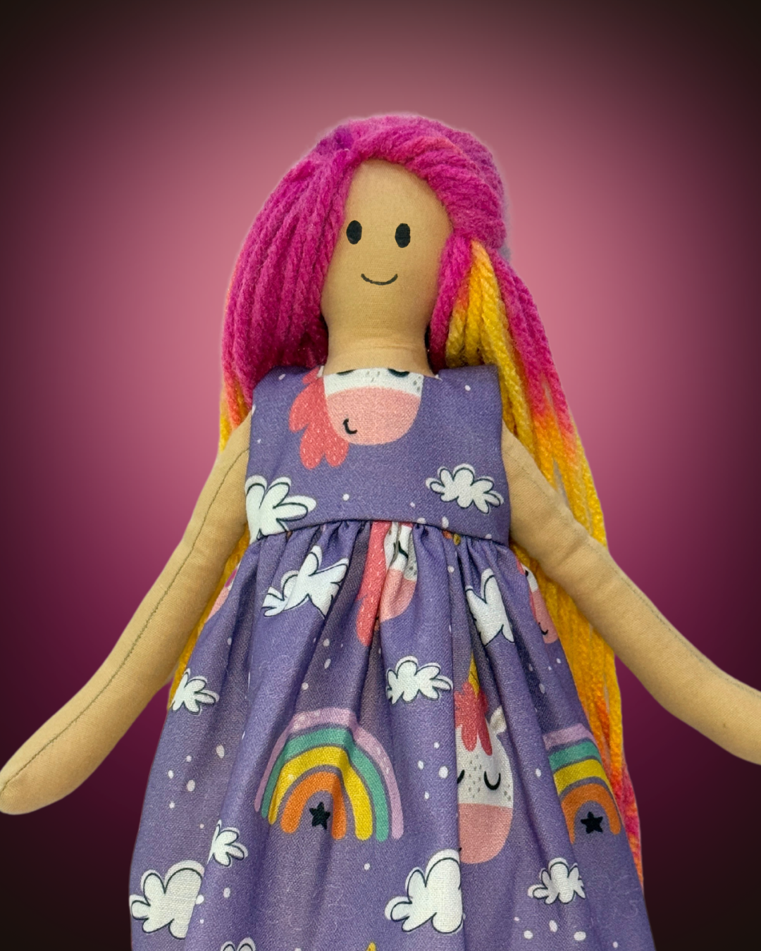 Eco-friendly handmade rag doll dressed in a purple unicorn print dress, featuring vibrant pink hair and tangle-free yarn strands